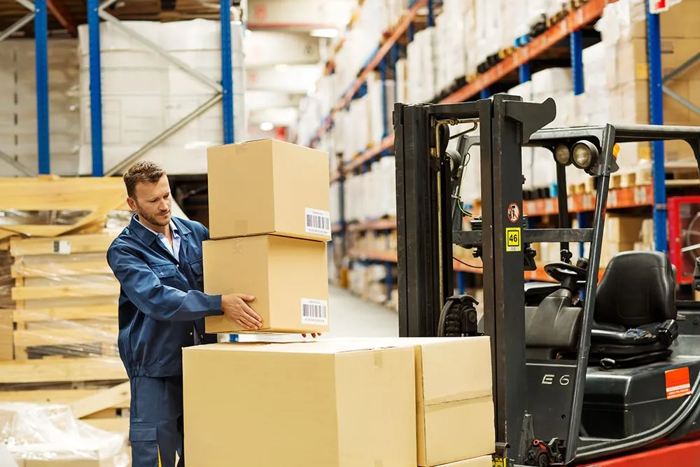 Warehouse employees offloading freight from trailer at cross-dock facility